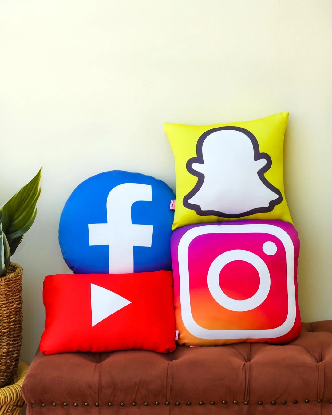 Custom shaped pillows of social media logos on a bench